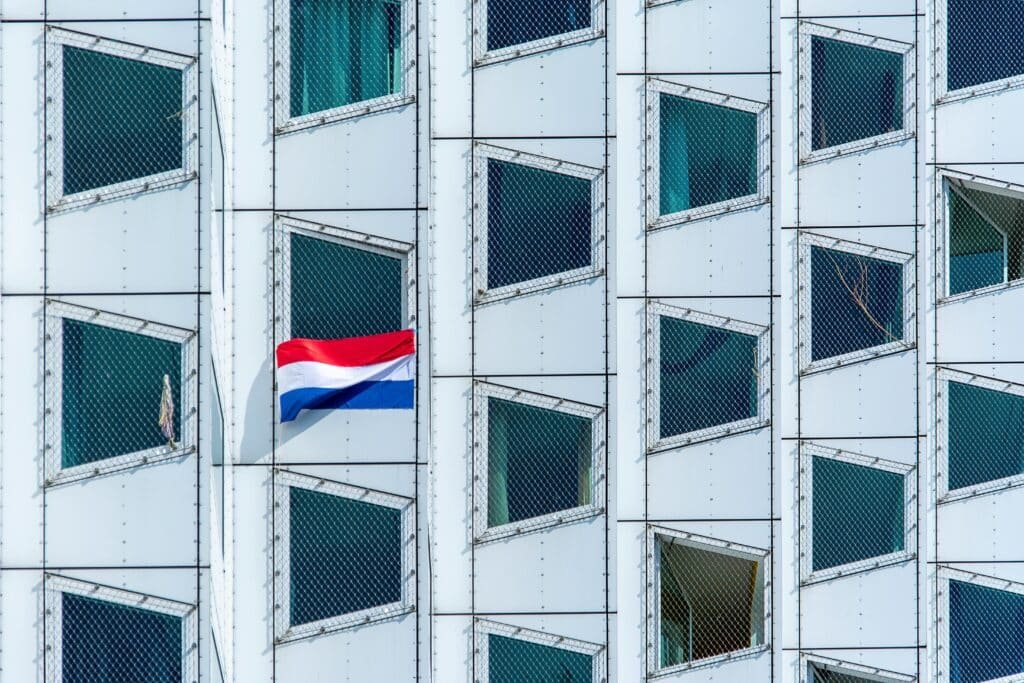 An abstract facade featuring a Dutch flag with geometric window patterns.